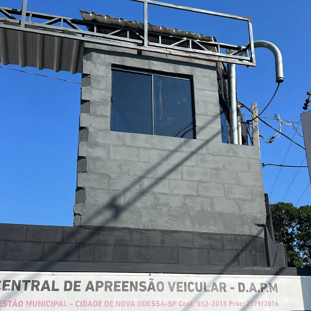 Janela de correr em vidro escuro instalada em parede de bloco