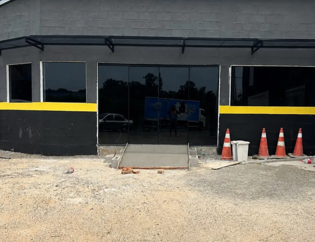 Fachada comercial preta com porta e janelas de vidro