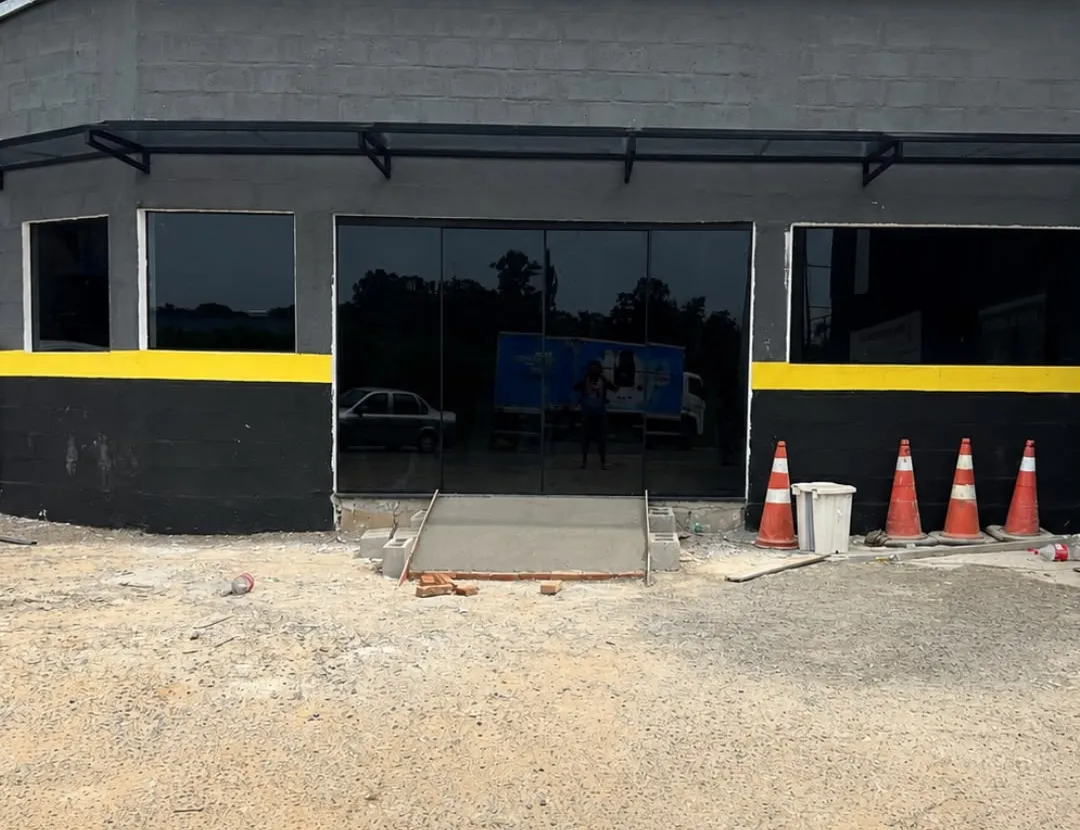 Fachada comercial preta com porta e janelas de vidro