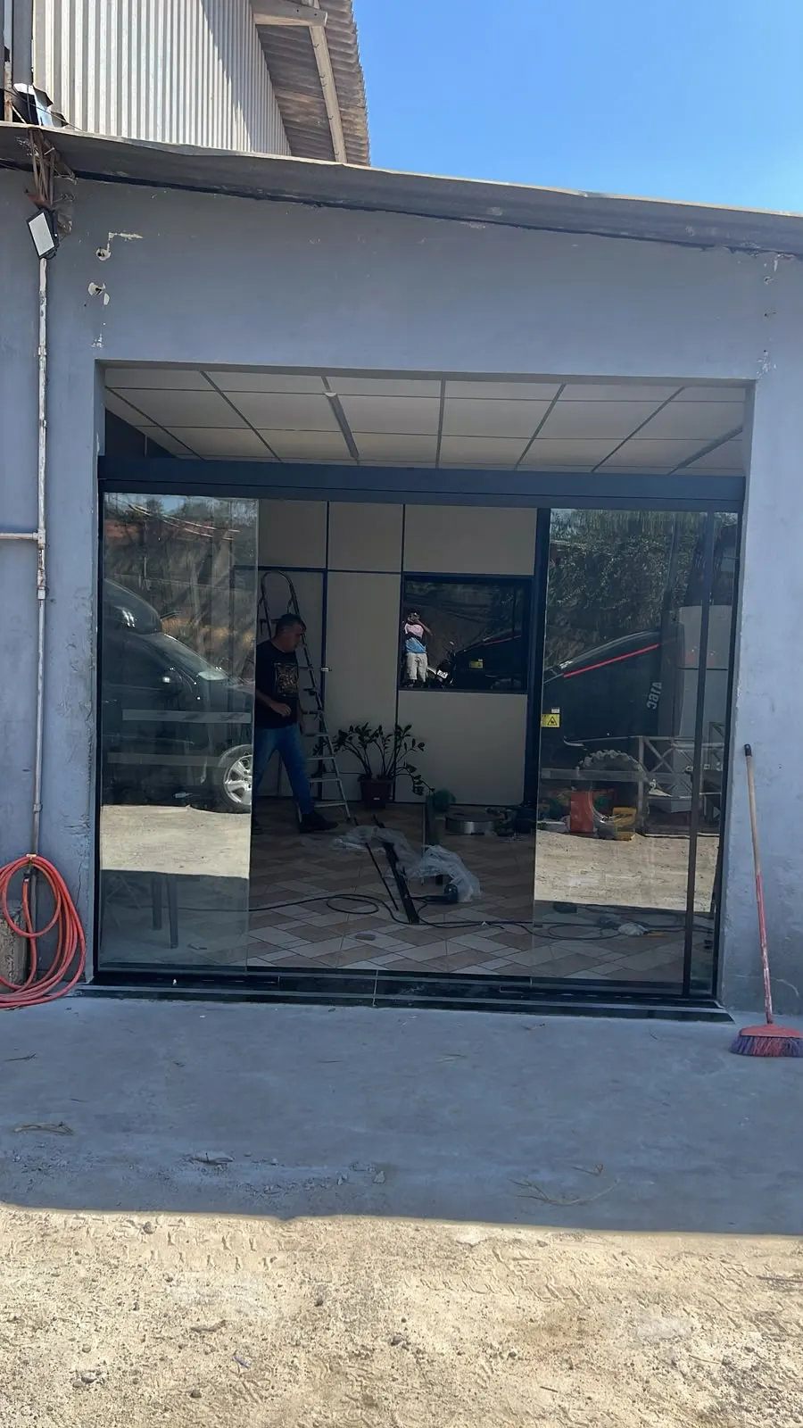 Frente de imóvel comercial fechada com painéis e portas de vidro