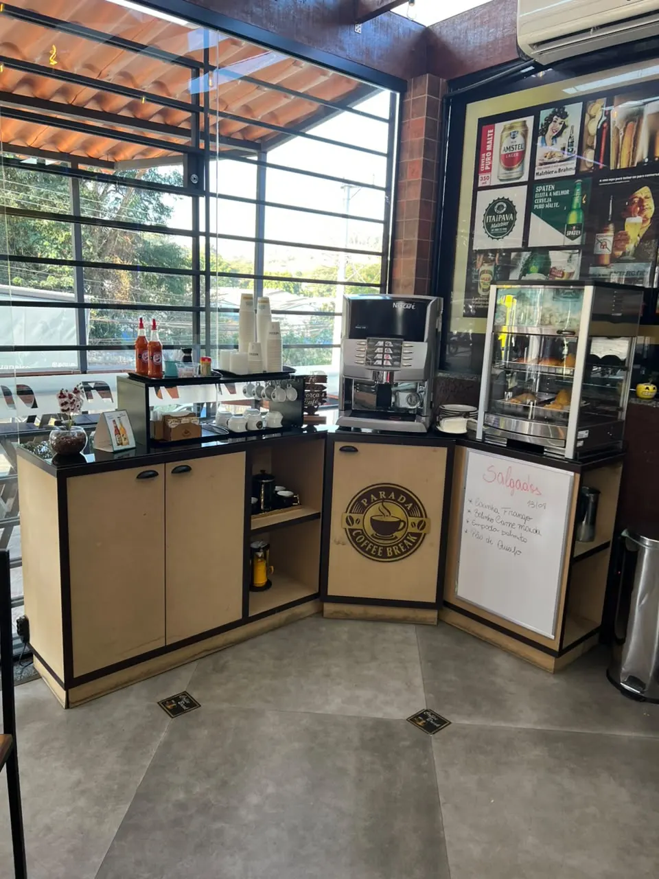 Balcão de canto de cafeteria, com tampo preto e portas claras