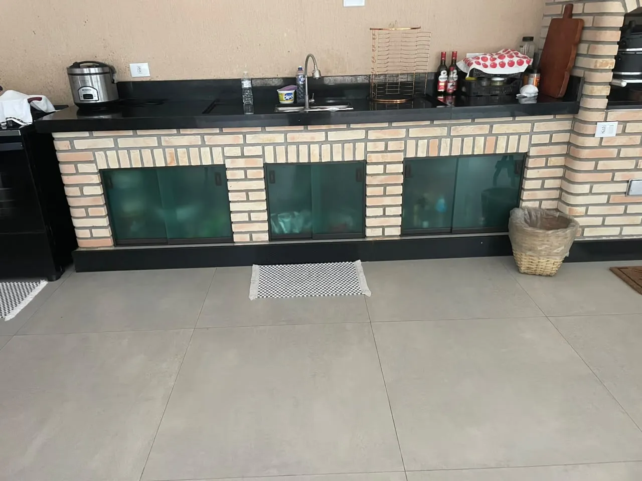 Bancada de tijolo aparente com portas de correr em vidro verde